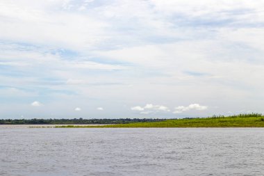 Rio Negro 'nun karasu suyu Amazon Nehri' nin beyaz suyu ve tropikal orman yağmur ormanı ve Iranduba Manaus Manaus Brezilya 'da mavi bulutlu gökyüzü ile tekne turu..