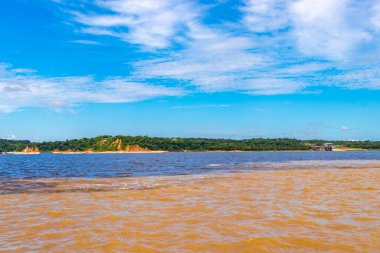 Rio Negro 'nun karasu suyu Amazon Nehri' nin beyaz suyu ve tropikal orman yağmur ormanı ve Iranduba Manaus Manaus Brezilya 'da mavi bulutlu gökyüzü ile tekne turu..