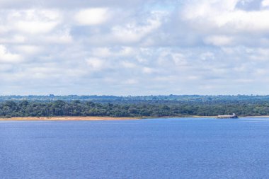 Rio Negro ve Amazon Nehri 'nin suları, tropikal yağmur ormanları ve mavi bulutlu gökyüzü İranduba Manaus Brezilya Eyaleti' ne tekne turunda..