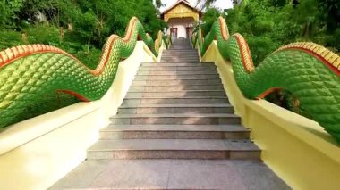 Kathu Bölgesi Phuket Adası 26. Tayland. Ekim 2025 Suwankeereewong Tapınağı Renkli yeşil naga ejderha yılan heykeli heykel heykel ve Patong Sahili Phuket Tayland merdivenleri.