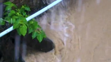 Güneydoğu Asya 'daki Güney Tayland' da Patong Sahili Katu Bölgesi Phuket Adası Eyaleti 'nde şiddetli bir muson yağmuru sırasında küçük tropikal yeşil şehir nehir kanalı ve orman dokusunda drenaj..