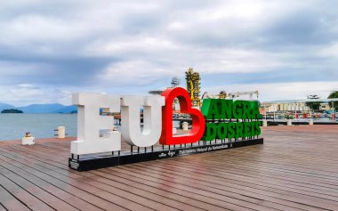 Angra dos Reis Rio de Janeiro Brezilya Eyaleti 26. Ekim 2020. Angra dos Reis 'i seviyorum. Rio de Janeiro Brezilya' da turkuaz su, yeşil dağlar ve mavi gökyüzü olan iskelede harfli harfleri imzalıyorum..