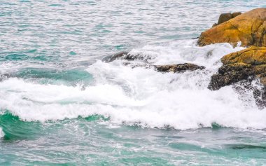 Rocky Kalim Plajı tropikal manzara manzarası turkuaz mavisi berrak su dalgaları ve kayalarla Patong Sahili Kathu Bölgesi Phuket Adası Güney Tayland.