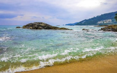 İnanılmaz kayalık Kalim Sahili tropikal manzara manzarası mavi gökyüzü turkuvaz su dalgaları ve kayalar ile Patong Sahili Kathu Bölgesi Phuket Adası Güney Tayland.