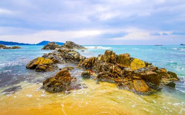 İnanılmaz kayalık Kalim Sahili tropikal manzara manzarası mavi gökyüzü turkuvaz su dalgaları ve kayalar ile Patong Sahili Kathu Bölgesi Phuket Adası Güney Tayland.