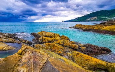 İnanılmaz kayalık Kalim Sahili tropikal manzara manzarası mavi gökyüzü turkuvaz su dalgaları ve kayalar ile Patong Sahili Kathu Bölgesi Phuket Adası Güney Tayland.