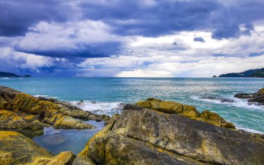 İnanılmaz kayalık Kalim Sahili tropikal manzara manzarası mavi gökyüzü turkuvaz su dalgaları ve kayalar ile Patong Sahili Kathu Bölgesi Phuket Adası Güney Tayland.