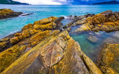 İnanılmaz kayalık Kalim Sahili tropikal manzara manzarası mavi gökyüzü turkuvaz su dalgaları ve kayalar ile Patong Sahili Kathu Bölgesi Phuket Adası Güney Tayland.