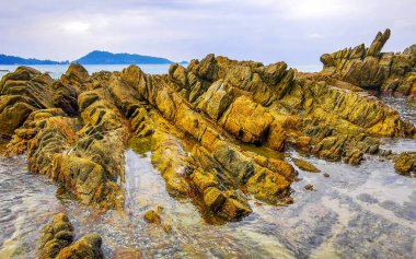 İnanılmaz kayalık Kalim Sahili tropikal manzara manzarası mavi gökyüzü turkuvaz su dalgaları ve kayalar ile Patong Sahili Kathu Bölgesi Phuket Adası Güney Tayland.