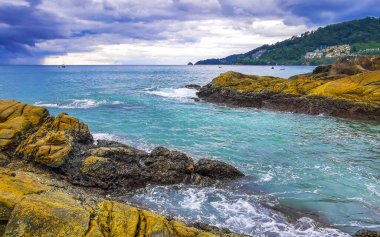 Rocky Kalim Plajı tropikal manzara manzarası turkuaz mavisi berrak su dalgaları ve kayalarla Patong Sahili Kathu Bölgesi Phuket Adası Güney Tayland.