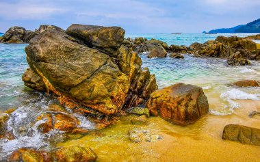 İnanılmaz kayalık Kalim Sahili tropikal manzara manzarası mavi gökyüzü turkuvaz su dalgaları ve kayalar ile Patong Sahili Kathu Bölgesi Phuket Adası Güney Tayland.
