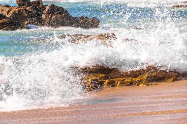Rocky Kalim Plajı tropikal manzara manzarası turkuvaz mavisi temiz su dalgaları ile Patong Sahili 'nde Kathu Bölgesi Phuket Adası Güney Tayland' da kum ve kayalar.
