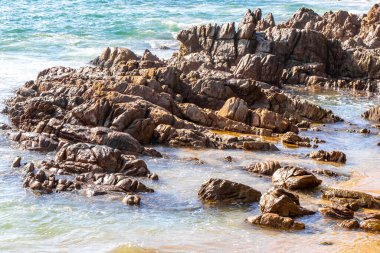 Rocky Kalim Plajı tropikal manzara manzarası turkuvaz mavisi temiz su dalgaları ile Patong Sahili 'nde Kathu Bölgesi Phuket Adası Güney Tayland' da kum ve kayalar.