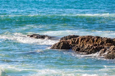 Rocky Kalim Plajı tropikal manzara manzarası turkuvaz mavisi temiz su dalgaları ile Patong Sahili 'nde Kathu Bölgesi Phuket Adası Güney Tayland' da kum ve kayalar.