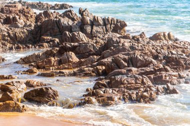 Rocky Kalim Plajı tropikal manzara manzarası turkuvaz mavisi temiz su dalgaları ile Patong Sahili 'nde Kathu Bölgesi Phuket Adası Güney Tayland' da kum ve kayalar.