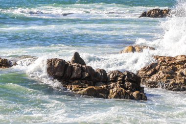 Rocky Kalim Plajı tropikal manzara manzarası turkuvaz mavisi temiz su dalgaları ile Patong Sahili 'nde Kathu Bölgesi Phuket Adası Güney Tayland' da kum ve kayalar.