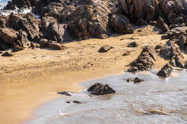 Rocky Kalim Plajı tropikal manzara manzarası turkuvaz mavisi temiz su dalgaları ile Patong Sahili 'nde Kathu Bölgesi Phuket Adası Güney Tayland' da kum ve kayalar.