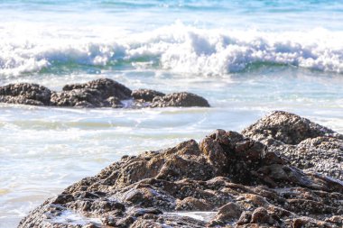Rocky Kalim Plajı tropikal manzara manzarası turkuvaz mavisi temiz su dalgaları ile Patong Sahili 'nde Kathu Bölgesi Phuket Adası Güney Tayland' da kum ve kayalar.