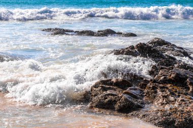 Rocky Kalim Plajı tropikal manzara manzarası turkuvaz mavisi temiz su dalgaları ile Patong Sahili 'nde Kathu Bölgesi Phuket Adası Güney Tayland' da kum ve kayalar.