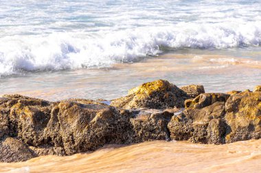 Rocky Kalim Plajı tropikal manzara manzarası turkuvaz mavisi temiz su dalgaları ile Patong Sahili 'nde Kathu Bölgesi Phuket Adası Güney Tayland' da kum ve kayalar.