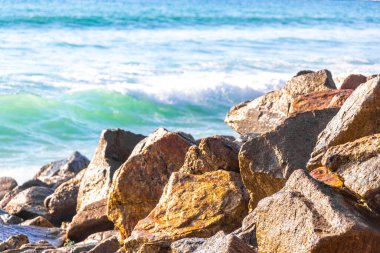 Rocky Kalim Plajı tropikal manzara manzarası turkuvaz mavisi temiz su dalgaları ile Patong Sahili 'nde Kathu Bölgesi Phuket Adası Güney Tayland' da kum ve kayalar.