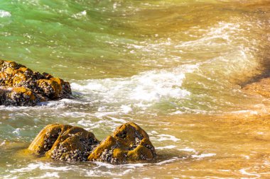 Rocky Kalim Plajı tropikal manzara manzarası turkuvaz mavisi temiz su dalgaları ile Patong Sahili 'nde Kathu Bölgesi Phuket Adası Güney Tayland' da kum ve kayalar.
