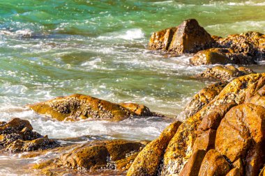 Rocky Kalim Plajı tropikal manzara manzarası turkuvaz mavisi temiz su dalgaları ile Patong Sahili 'nde Kathu Bölgesi Phuket Adası Güney Tayland' da kum ve kayalar.