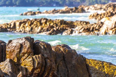 Rocky Kalim Plajı tropikal manzara manzarası turkuvaz mavisi temiz su dalgaları ile Patong Sahili 'nde Kathu Bölgesi Phuket Adası Güney Tayland' da kum ve kayalar.
