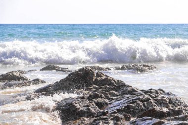Rocky Kalim Plajı tropikal manzara manzarası turkuvaz mavisi temiz su dalgaları ile Patong Sahili 'nde Kathu Bölgesi Phuket Adası Güney Tayland' da kum ve kayalar.