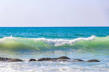 Rocky Kalim Plajı tropikal manzara manzarası turkuvaz mavisi temiz su dalgaları ile Patong Sahili 'nde Kathu Bölgesi Phuket Adası Güney Tayland' da kum ve kayalar.