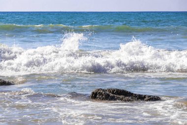 Rocky Kalim Plajı tropikal manzara manzarası turkuvaz mavisi temiz su dalgaları ile Patong Sahili 'nde Kathu Bölgesi Phuket Adası Güney Tayland' da kum ve kayalar.