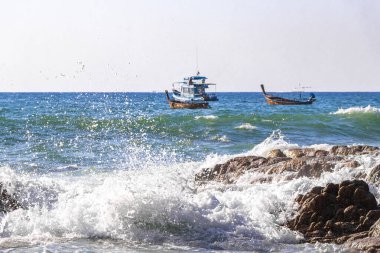 Rocky Kalim Plajı tropikal manzara manzarası turkuvaz mavisi temiz su dalgaları ile Patong Sahili 'nde Kathu Bölgesi Phuket Adası Güney Tayland' da kum ve kayalar.