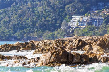 Rocky Kalim Plajı tropikal manzara manzarası turkuvaz mavisi temiz su dalgaları ile Patong Sahili 'nde Kathu Bölgesi Phuket Adası Güney Tayland' da kum ve kayalar.
