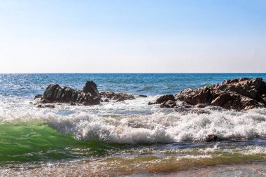 Rocky Kalim Plajı tropikal manzara manzarası turkuvaz mavisi temiz su dalgaları ile Patong Sahili 'nde Kathu Bölgesi Phuket Adası Güney Tayland' da kum ve kayalar.