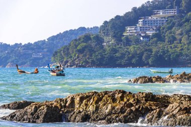 Rocky Kalim Plajı tropikal manzara manzarası turkuvaz mavisi temiz su dalgaları ile Patong Sahili 'nde Kathu Bölgesi Phuket Adası Güney Tayland' da kum ve kayalar.