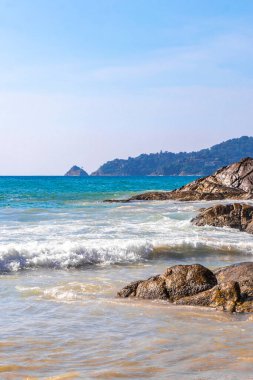 Rocky Kalim Plajı tropikal manzara manzarası turkuvaz mavisi temiz su dalgaları ile Patong Sahili 'nde Kathu Bölgesi Phuket Adası Güney Tayland' da kum ve kayalar.