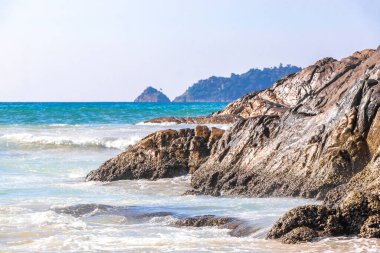 Rocky Kalim Plajı tropikal manzara manzarası turkuvaz mavisi temiz su dalgaları ile Patong Sahili 'nde Kathu Bölgesi Phuket Adası Güney Tayland' da kum ve kayalar.
