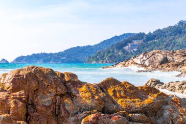 Rocky Kalim Plajı tropikal manzara manzarası turkuvaz mavisi temiz su dalgaları ile Patong Sahili 'nde Kathu Bölgesi Phuket Adası Güney Tayland' da kum ve kayalar.