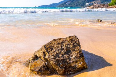 Rocky Kalim Plajı tropikal manzara manzarası turkuvaz mavisi temiz su dalgaları ile Patong Sahili 'nde Kathu Bölgesi Phuket Adası Güney Tayland' da kum ve kayalar.