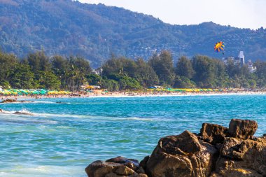 Rocky Kalim Plajı tropikal manzara manzarası turkuvaz mavisi temiz su dalgaları ile Patong Sahili 'nde Kathu Bölgesi Phuket Adası Güney Tayland' da kum ve kayalar.