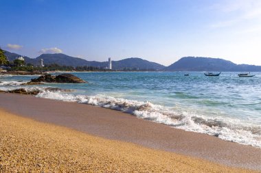 Rocky Kalim Plajı tropikal manzara manzarası turkuvaz mavisi temiz su dalgaları ile Patong Sahili 'nde Kathu Bölgesi Phuket Adası Güney Tayland' da kum ve kayalar.