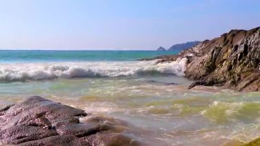 Rocky Kalim Plajı tropikal manzara manzarası turkuvaz mavisi temiz su dalgaları ile Patong Sahili 'nde Kathu Bölgesi Phuket Adası Güney Tayland' da kum ve kayalar.