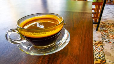 Güneydoğu Asya 'da Patong Plajı' ndaki Kathu Bölgesi Phuket Adası Bölgesi Tayland Eyaleti 'nde bir kafeteryada kaşık ve tabakla birlikte bir bardak americano kahvesi..