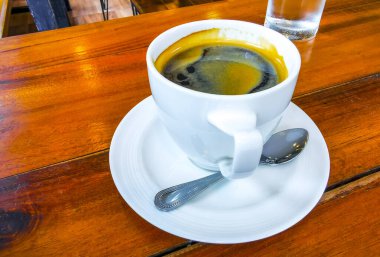 Güneydoğu Asya 'da Patong Plajı' ndaki Kathu Bölgesi Phuket Adası Bölgesi Tayland Eyaleti 'nde bir kafeteryada kaşık ve tabakla birlikte bir bardak americano kahvesi..