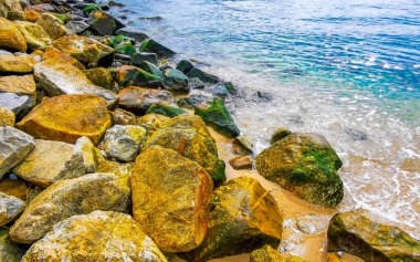 Kalim Sahili tropikal kayalık manzara manzarası turkuaz mavisi berrak su dalgaları ile Patong Sahili Kathu Bölgesi Phuket Adası Güney Tayland 'da kum ve kayalar.