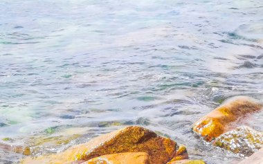 Kalim Sahili tropik kayalık deniz manzarası turkuvaz mavisi berrak su dalgaları ile Patong Sahili 'nde Kathu Bölgesi Phuket Adası Güney Tayland' da kum ve kayalar.