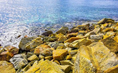 Kalim Sahili tropik kayalık deniz manzarası turkuvaz mavisi berrak su dalgaları ile Patong Sahili 'nde Kathu Bölgesi Phuket Adası Güney Tayland' da kum ve kayalar.