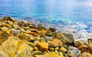 Kalim Sahili tropik kayalık deniz manzarası turkuvaz mavisi berrak su dalgaları ile Patong Sahili 'nde Kathu Bölgesi Phuket Adası Güney Tayland' da kum ve kayalar.