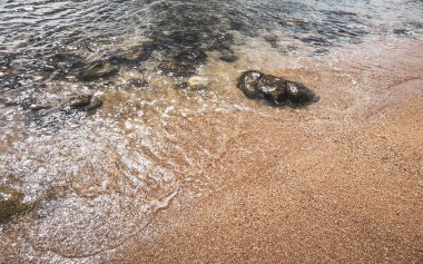 Kalim Sahili tropik kayalık deniz manzarası turkuvaz mavisi berrak su dalgaları ile Patong Sahili 'nde Kathu Bölgesi Phuket Adası Güney Tayland' da kum ve kayalar.