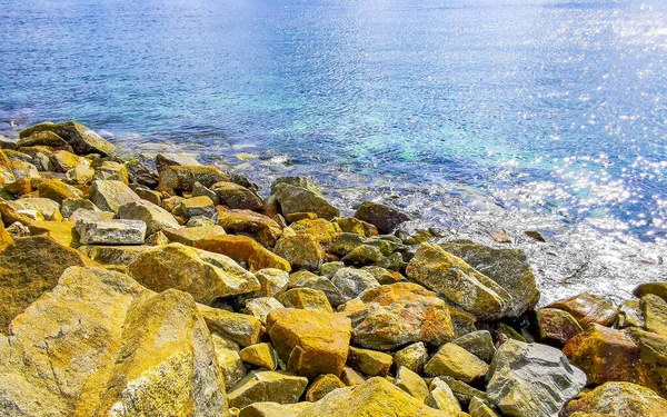 Kalim Sahili tropik kayalık deniz manzarası turkuvaz mavisi berrak su dalgaları ile Patong Sahili 'nde Kathu Bölgesi Phuket Adası Güney Tayland' da kum ve kayalar.